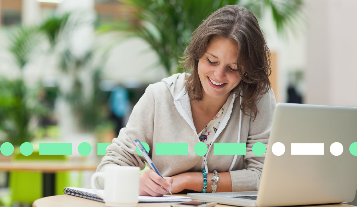 happy lady using laptop and writing notes