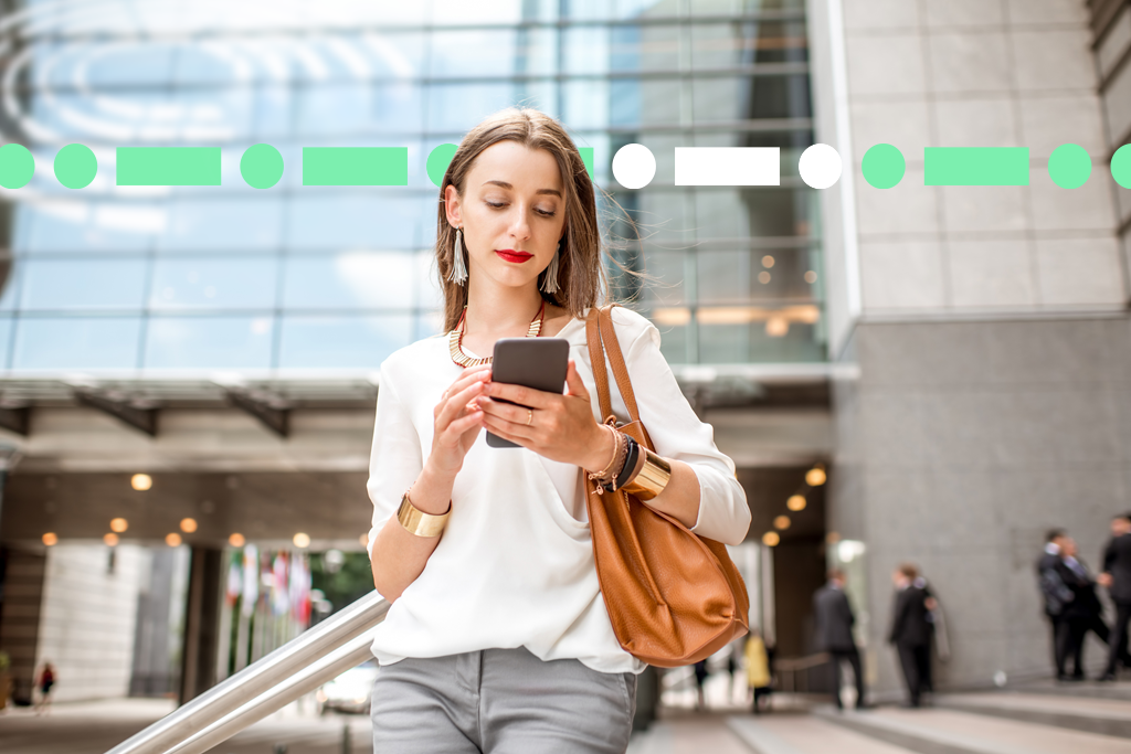 Office worker checking her phone outside of office